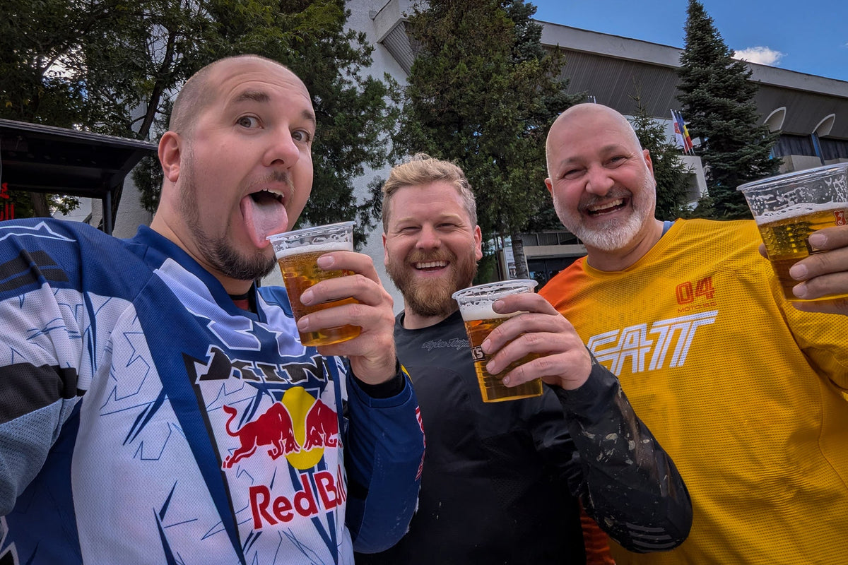 Sam in Romania with his friends having a drink after riding their motorcycles off road.