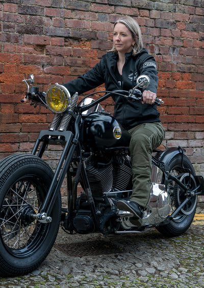 Lady on a motorcycle wearing olive coloured motorcycle trousers.